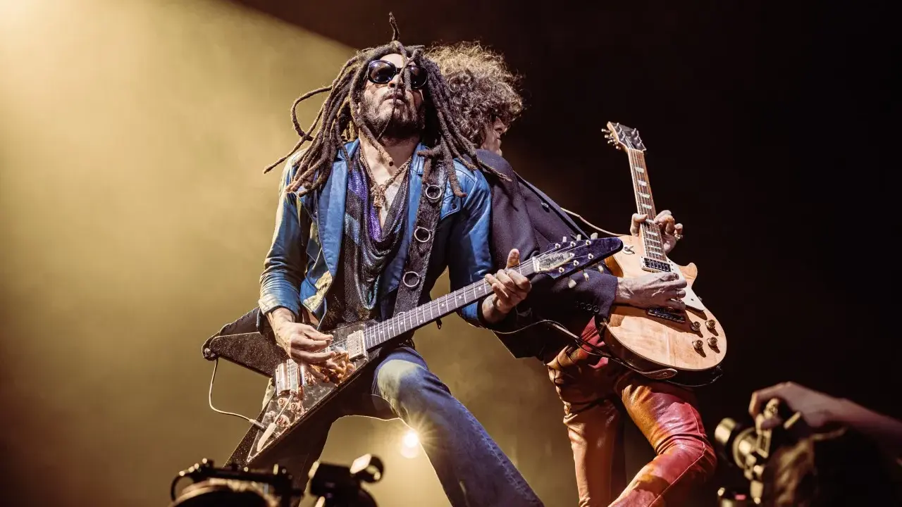 Lenny Kravitz, icône du rock, joue de la guitare sur scène, une image qui pourrait figurer sur un album.