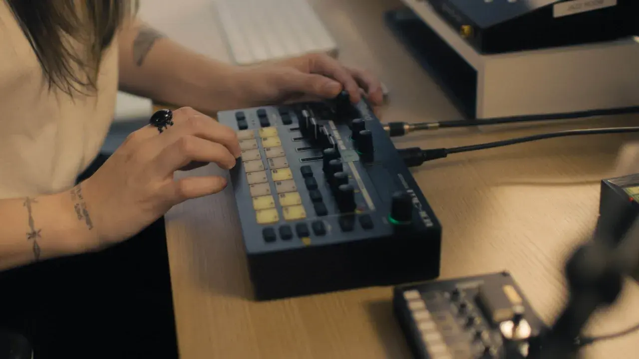 Main d'une personne manipulant une console de musique, un pas vers comment trouver un producteur de musique.