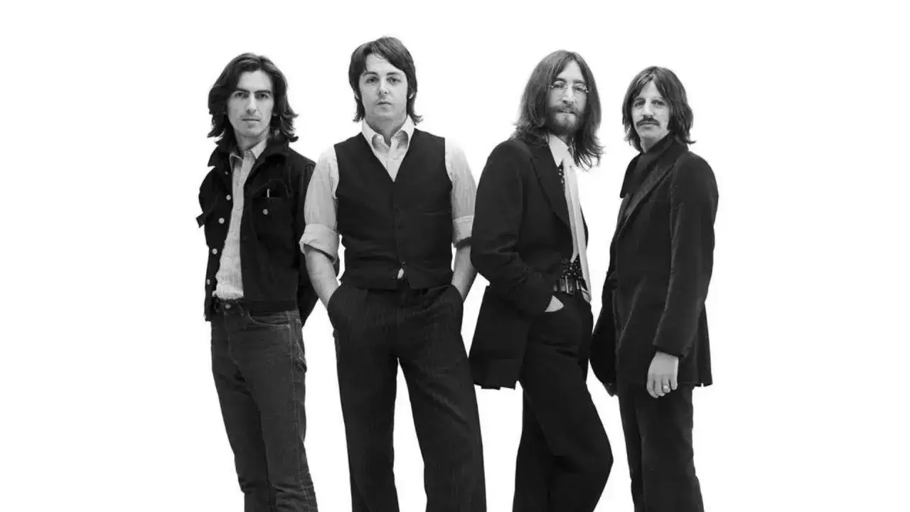 La composition des Beatles, quatre musiciens emblématiques posant ensemble sur fond blanc.