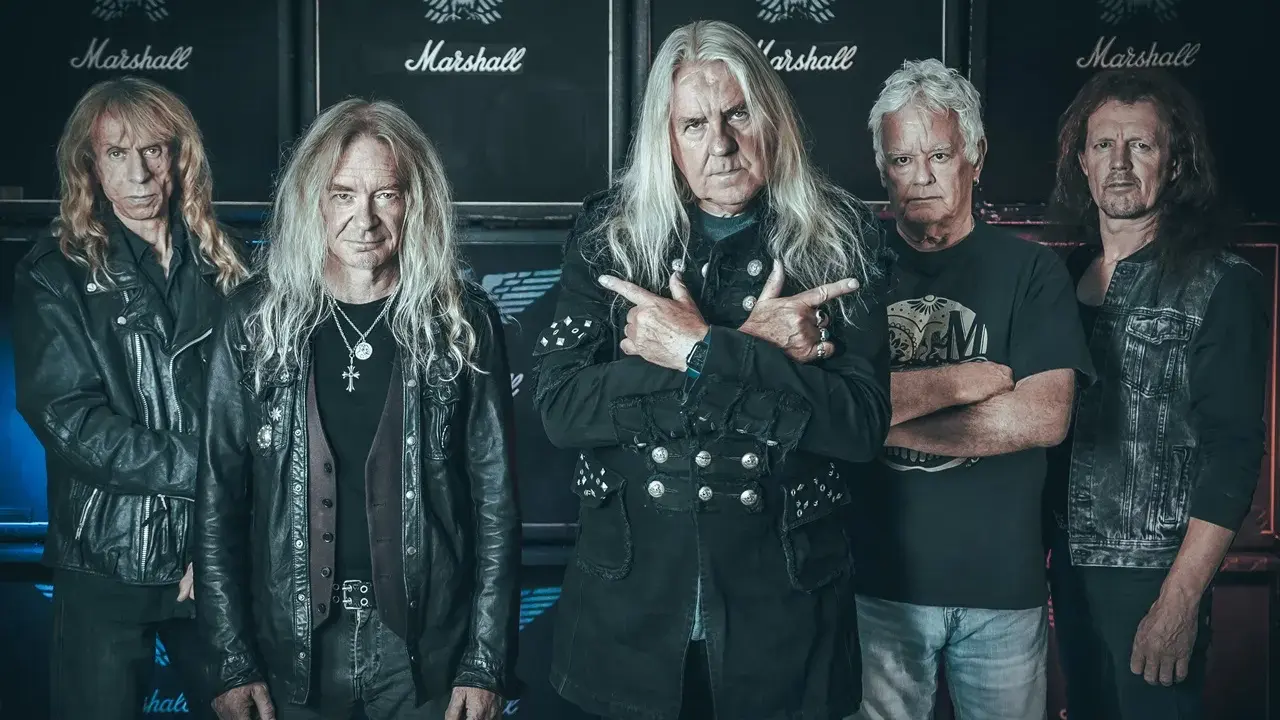 Le groupe Saxon, cinq musiciens aux cheveux longs, pose devant des amplis Marshall.