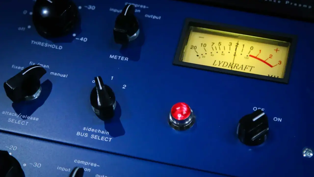 Gros plan sur un appareil audio bleu, avec des boutons et un VU-mètre. Idéal pour l'enregistrement voix.