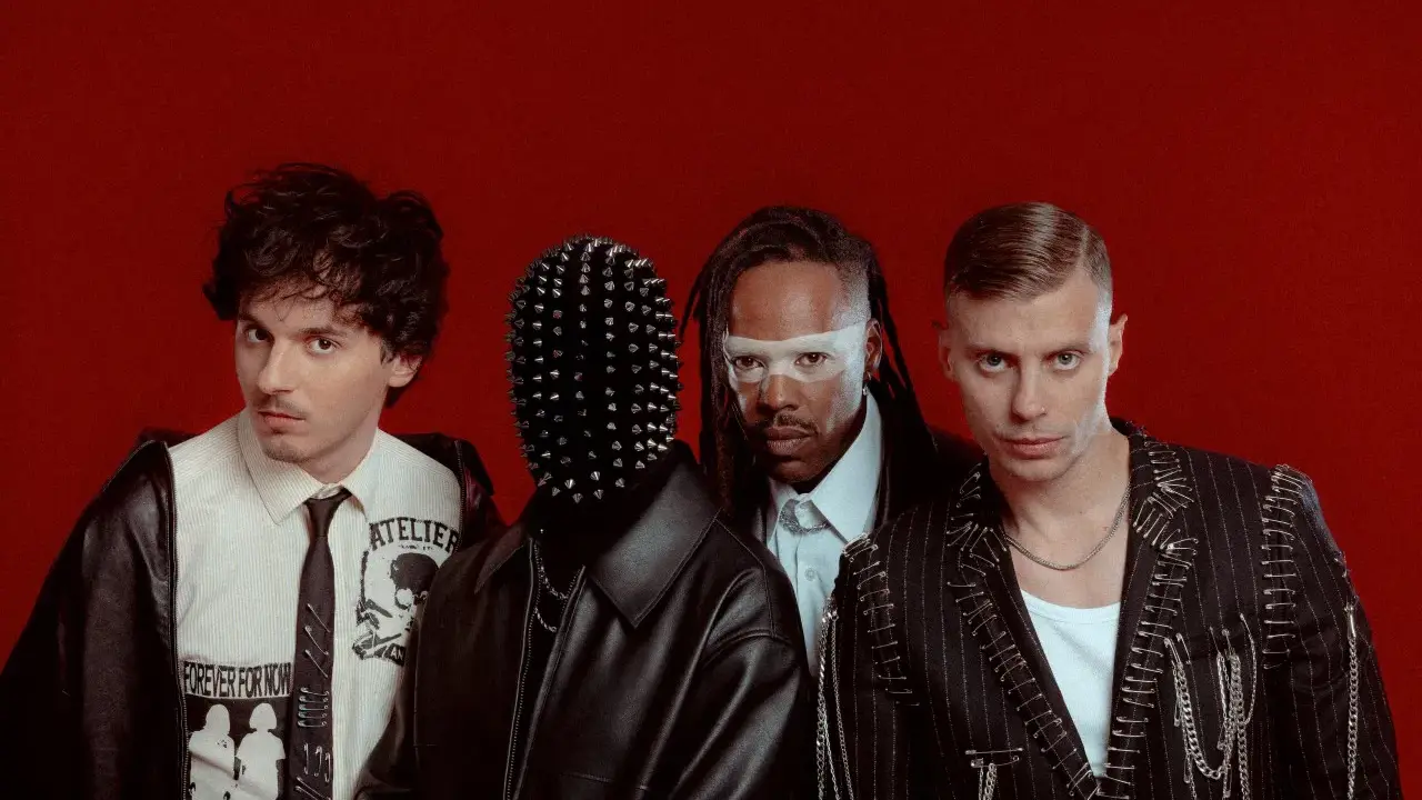 Les membres de Skip the Use posent sur fond rouge, avec des looks audacieux et stylisés.