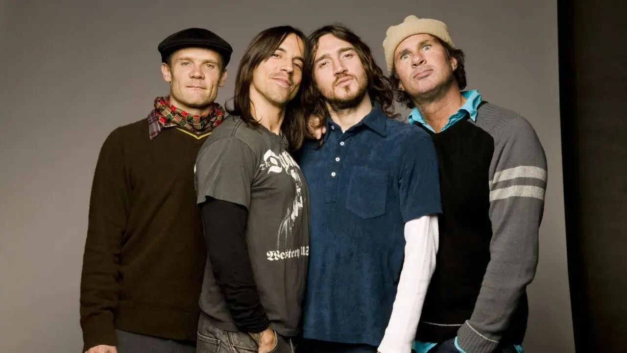 Les membres des Red Hot Chili Peppers posent ensemble, un groupe de rock légendaire.