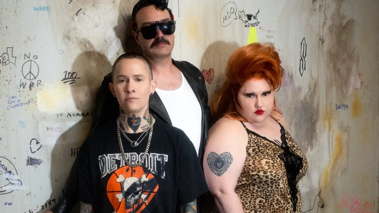 Un groupe d'amis, un vrai gossip groupe, pose devant un mur tagué. L'un porte un t-shirt "Detroit", l'autre une robe léopard, le troisième des lunettes de soleil.