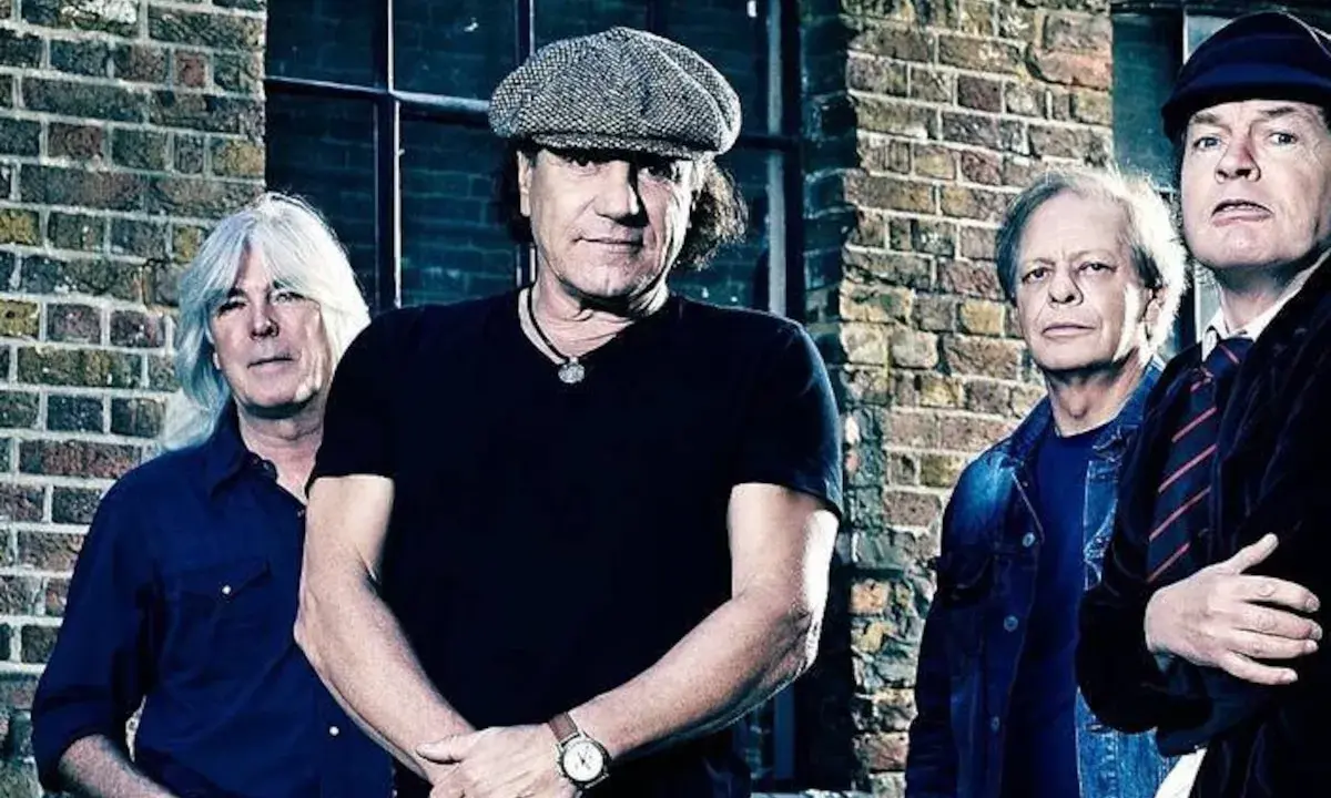 Les membres d'AC/DC posent devant un mur de briques, rappelant l'énergie brute de leurs albums.