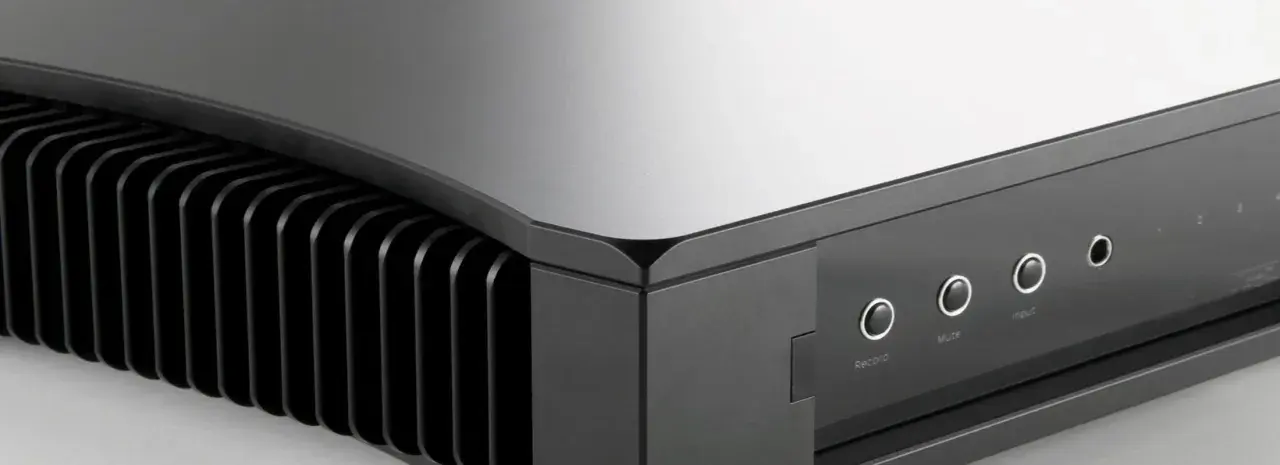 Gros plan sur le Rega Aethos, amplificateur hi-fi au design épuré avec ses ailettes de refroidissement et ses boutons de commande.
