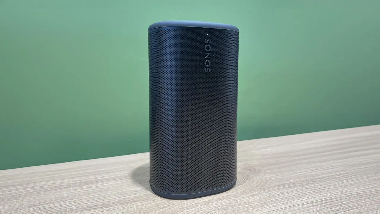 Enceinte Sonos noire sur une table en bois, prête à diffuser votre musique bluetooth préférée.
