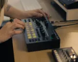 Main d'une personne manipulant une console de musique, un pas vers comment trouver un producteur de musique.