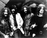 Les quatre membres de Black Sabbath posent devant une arche rocheuse, prêts à enregistrer leur premier album.