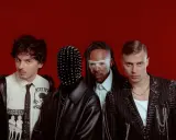 Les membres de Skip the Use posent sur fond rouge, avec des looks audacieux et stylisés.
