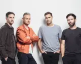 Le groupe Keane pose pour une photo, quatre hommes regardant la caméra.