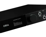 Un appareil audio noir ORIA avec un écran affichant des niveaux de sortie surround. Les commandes incluent un grand bouton rotatif et des boutons pour le volume, le profil, le down mix et la fonction, suggérant une expérience sonore immersive comme Dol...