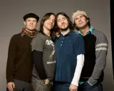 Les membres des Red Hot Chili Peppers posent ensemble, un groupe de rock légendaire.