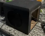 Un caisson de basse noir ouvert sur une table. Pour savoir si un caisson de basse fonctionne, vérifiez les connexions et le circuit imprimé.