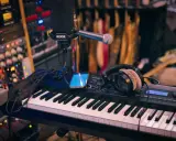 Clavier, micro, casque et smartphone sur un bureau de mixage. L'équipement parfait pour savoir comment se lancer dans la musique.