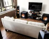 Salon moderne avec canapé clair, TV et système audio Klipsch pour une expérience sonore immersive, que ce soit en PCM ou Dolby Digital.