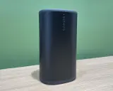 Enceinte Sonos noire sur une table en bois, prête à diffuser votre musique bluetooth préférée.