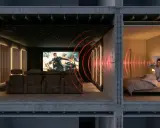 Une salle de cinéma privée avec fauteuils confortables et écran géant. À côté, une personne tente de dormir, dérangée par le bruit. Idéal pour **créer une salle de cinéma chez soi** sans déranger.