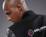 Un homme chauve porte une veste noire avec le logo "Golden Eye Music". Il est prêt à faire le buzz avec sa musique.