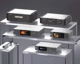 Plusieurs appareils audio haut de gamme, dont le meilleur préampli hifi du monde, sont présentés sur des étagères en verre.