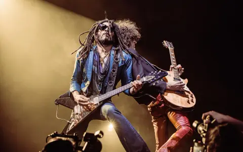 Lenny Kravitz, icône du rock, joue de la guitare sur scène, une image qui pourrait figurer sur un album.