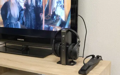 Un téléviseur Samsung diffuse un film, avec un casque sans fil sur son socle à côté. Idéal pour profiter du son tv et casque en même temps.