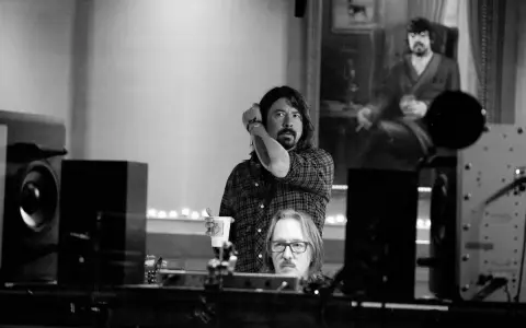 Dans ce studio d'enregistrement, deux hommes sont entourés d'équipements audio, créant une ambiance de **sound city**.