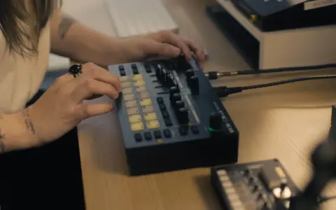 Main d'une personne manipulant une console de musique, un pas vers comment trouver un producteur de musique.