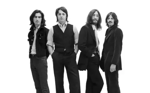 La composition des Beatles, quatre musiciens emblématiques posant ensemble sur fond blanc.