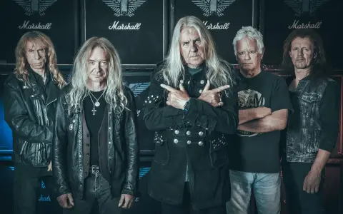 Le groupe Saxon, cinq musiciens aux cheveux longs, pose devant des amplis Marshall.