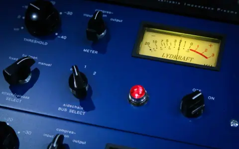 Gros plan sur un appareil audio bleu, avec des boutons et un VU-mètre. Idéal pour l'enregistrement voix.