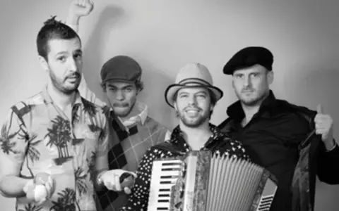 Le groupe java, avec son accordéoniste au centre, pose joyeusement. L'un des musiciens lève le poing, l'autre fait un clin d'œil.