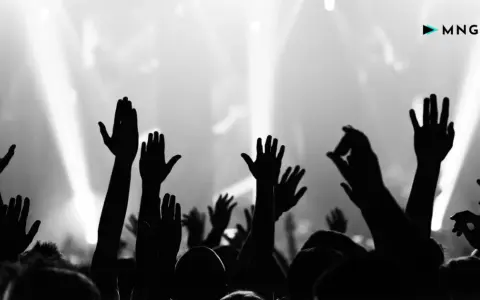 Foule en délire, mains levées vers la scène. Une image forte pour le marketing musical, capturant l'énergie d'un concert.