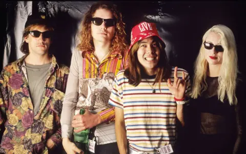 D'arcy Wretzky 2023, icône rock, pose avec les Smashing Pumpkins. Le groupe, dans un style années 90, arbore des tenues colorées et des lunettes de soleil.