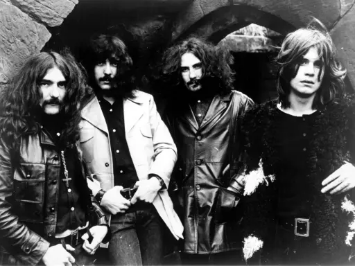 Les quatre membres de Black Sabbath posent devant une arche rocheuse, prêts à enregistrer leur premier album.