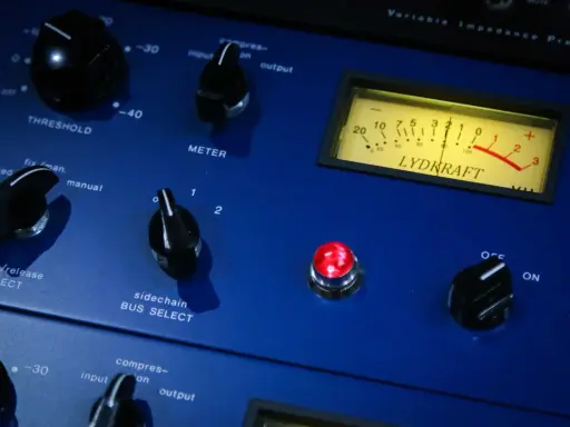 Gros plan sur un appareil audio bleu, avec des boutons et un VU-mètre. Idéal pour l'enregistrement voix.