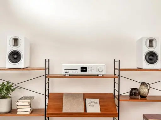 Élégant système audio blanc avec deux enceintes hifi et un lecteur CD sur des étagères en bois.