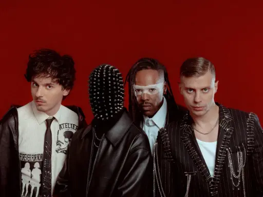 Les membres de Skip the Use posent sur fond rouge, avec des looks audacieux et stylisés.