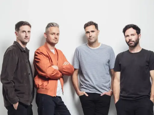 Le groupe Keane pose pour une photo, quatre hommes regardant la caméra.