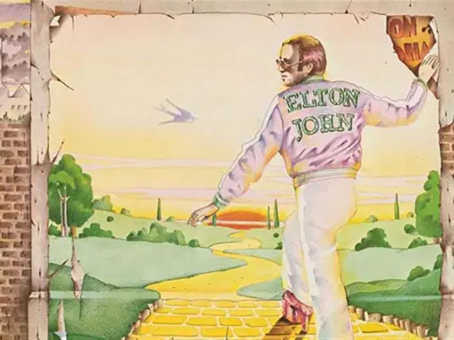 Elton John, sur la couverture du meilleur album Elton John, marche sur la route de briques jaunes vers un paysage idyllique.