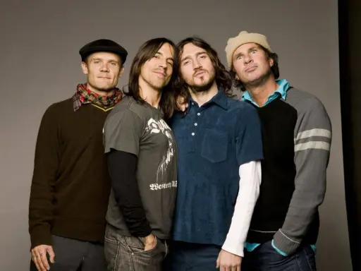 Les membres des Red Hot Chili Peppers posent ensemble, un groupe de rock légendaire.