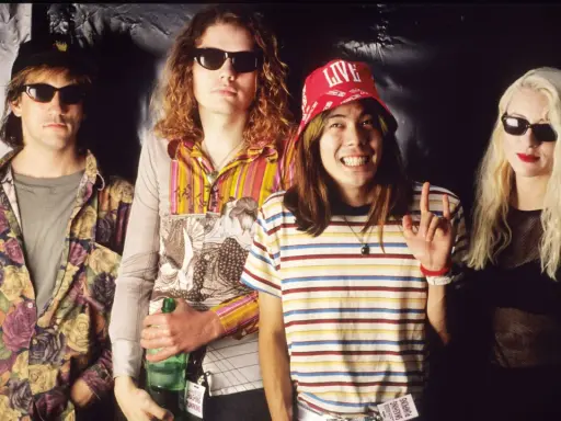 D'arcy Wretzky 2023, icône rock, pose avec les Smashing Pumpkins. Le groupe, dans un style années 90, arbore des tenues colorées et des lunettes de soleil.