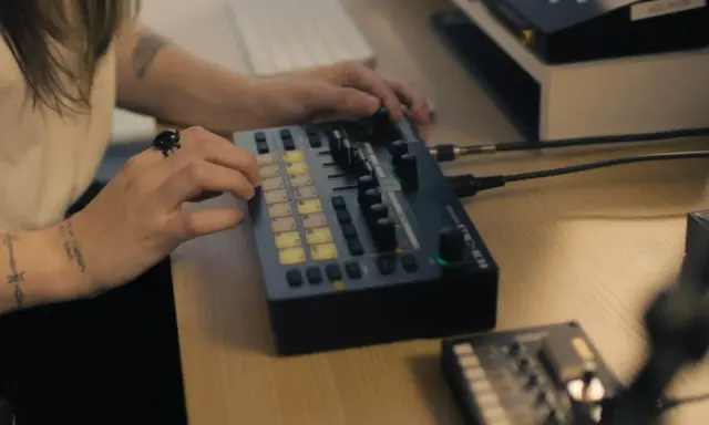 Main d'une personne manipulant une console de musique, un pas vers comment trouver un producteur de musique.