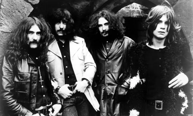 Les quatre membres de Black Sabbath posent devant une arche rocheuse, prêts à enregistrer leur premier album.