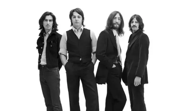 La composition des Beatles, quatre musiciens emblématiques posant ensemble sur fond blanc.