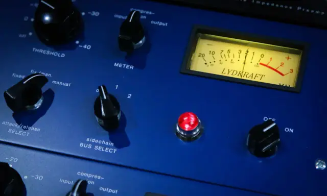 Gros plan sur un appareil audio bleu, avec des boutons et un VU-mètre. Idéal pour l'enregistrement voix.