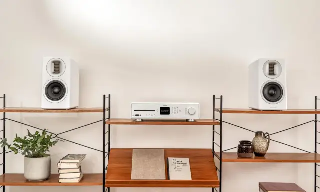 Élégant système audio blanc avec deux enceintes hifi et un lecteur CD sur des étagères en bois.
