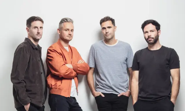 Le groupe Keane pose pour une photo, quatre hommes regardant la caméra.