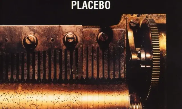 Mécanisme rouillé d'une boîte à musique, évoquant le "black market music" de Placebo. Des engrenages et des dents métalliques créent une mélodie sombre.