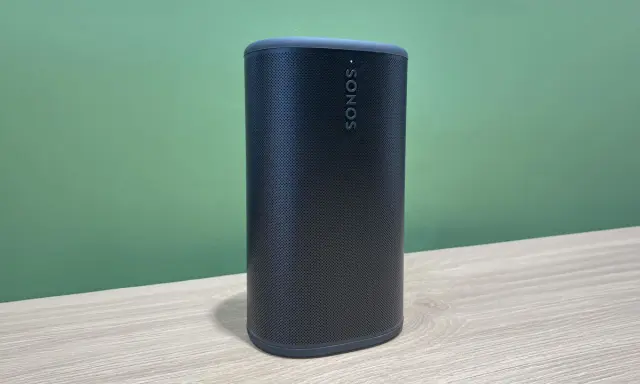 Enceinte Sonos noire sur une table en bois, prête à diffuser votre musique bluetooth préférée.